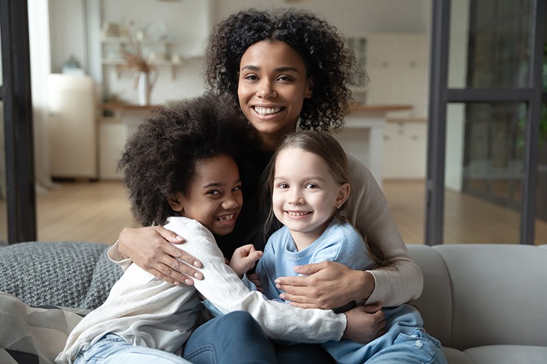 Portrait-of-biracial-mom-relax-with-multiethnic-daughters